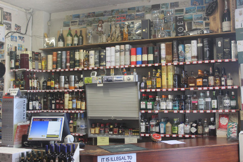 PWC website images035 Behind the till of portland wines with a wall of shelves with alcohol